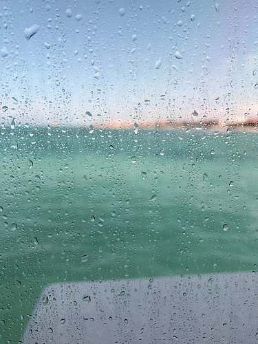 water drops dewdrops on glass window selective-focus photography at daytime wet